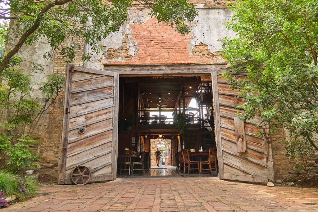 Large wooden doors open into Gristmill River Restaurant & Bar in historic Gruene, Texas.