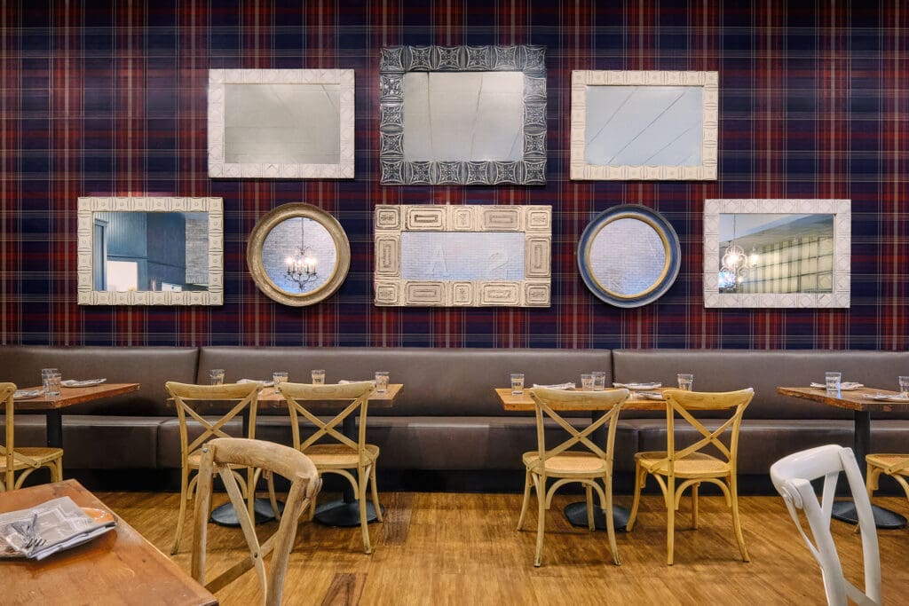 Plaid accent wall decorated with framed mirrors inside Honey Salt in Las Vegas.