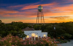 Gruene Hall and Gruene water tower beneath a colorful sunset in New Braunfels, Texas.