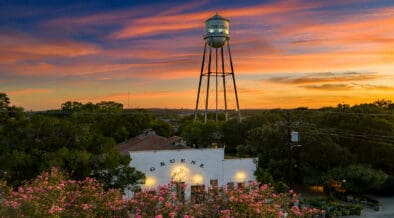Gruene Hall and Gruene water tower beneath a colorful sunset in New Braunfels, Texas.