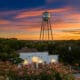 Gruene Hall and Gruene water tower beneath a colorful sunset in New Braunfels, Texas.